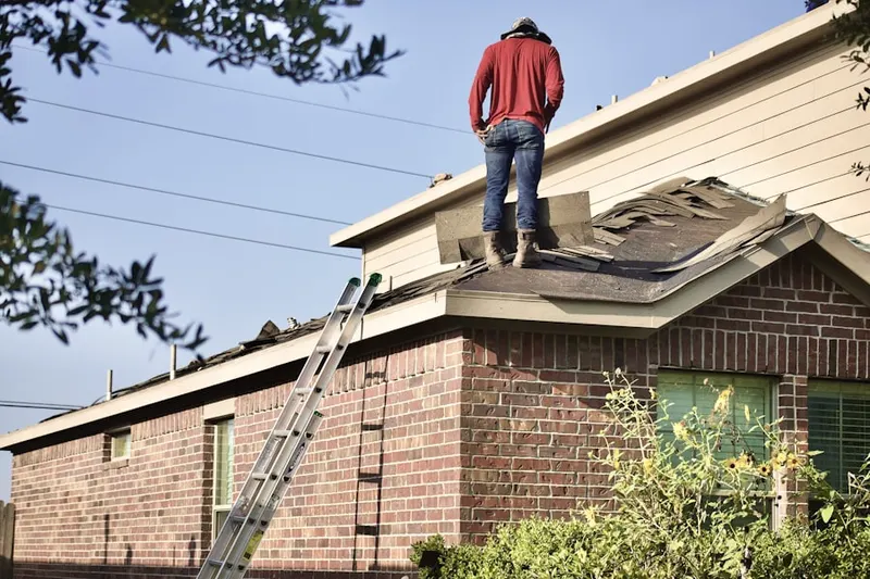 Professional roofer working on a residential roof in Huntsville